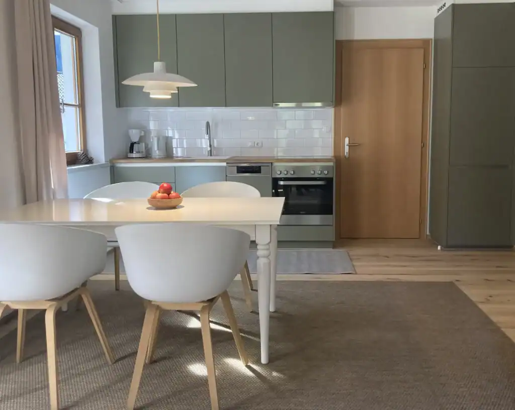 Helle Küche mit Essbereich, moderner Stil, Holz- und Pastellfarben, viel Tageslicht.